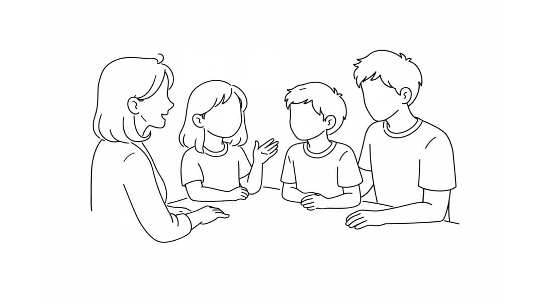 Zwei Erwachsene und zwei Kinder sitzen an einem Tisch und sprechen miteinander.